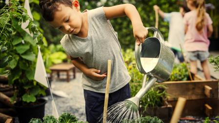 Junge gießt Gemüse zu Lebensmittelwertschätzung