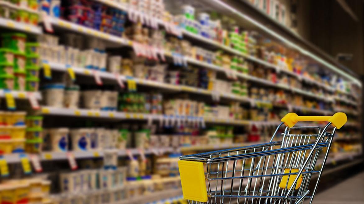 Einkaufswagen vor Regal im Supermarkt