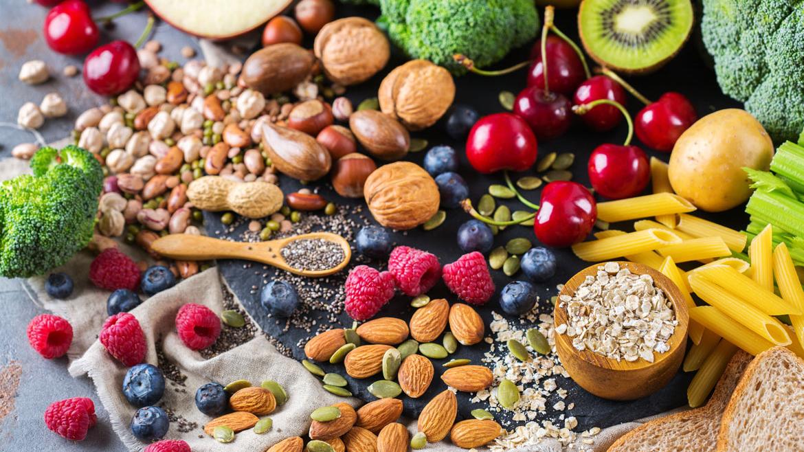 Obst, Gemüse, Nüsse, Getreide auf Tisch verteilt zu Artikel Vegane Ernährung für Kinder ungeeignet