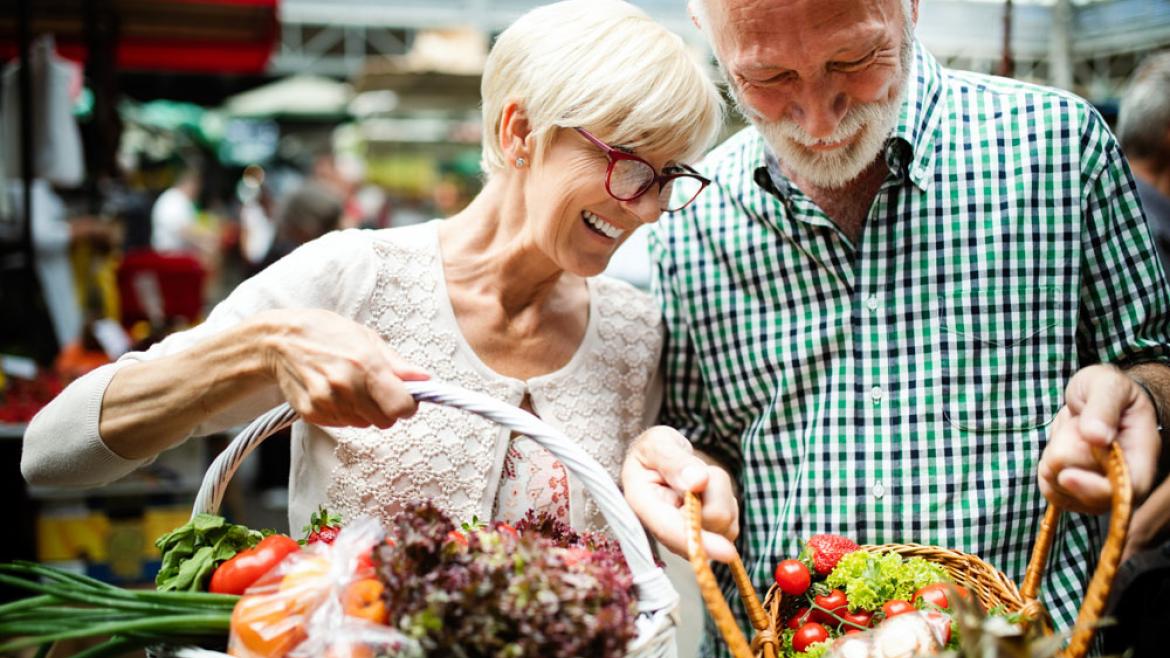 Älteres Paar kauft Obst und Gemüse auf Wochenmarkt