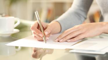 Frau schreibt Brief mit Hand