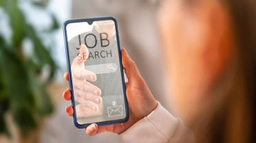Person hält Smartphone mit Jobangebot in Hand