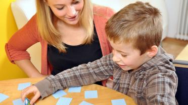 Kind spielt mit Memokarten