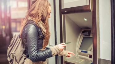 Junge Frau am geldautomat Finanzen