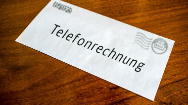 Telefonrechnung liegt auf Holztisch