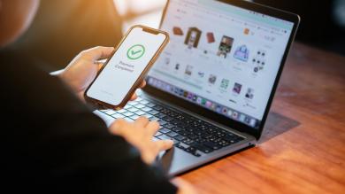 Mann nutzt Smartphone um Onlineeinkauf zu bezahlen