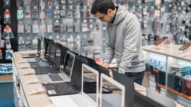 Mann will Laptop kaufen im Laden