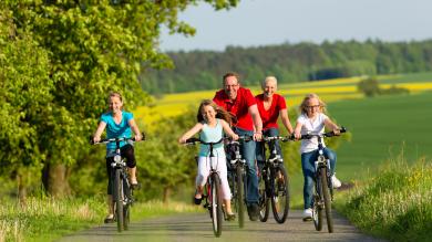 Familie fährt Rad, Natur im Hintergrund zu Artikel: Fahrradboom - Viele Fake-Shops tummeln sich im Netz