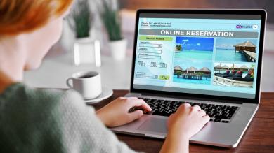 Frau sitzt vor geöffnetem Laptop zu Artikel: Ferienwohnung - Vorsicht vor gefälschten Internetangeboten