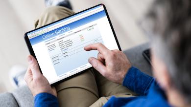 Mann auf Sofa mit Tablet beim Onlinebanking zum Artikel: Konto wechseln - so gehts
