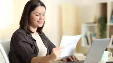 Frau mit Brief in Hand vor Laptop zu nowenergy