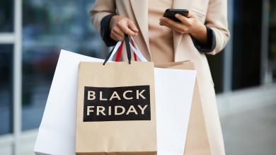 Frau mit Einkaufstüten. Auf einer steht Black Friday
