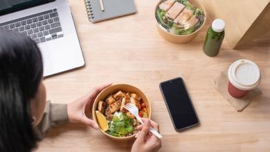 Frau im Büro isst gesundes Mittagessen 