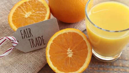 Glas mit Orangensaft und Etikett mit Fairtrade