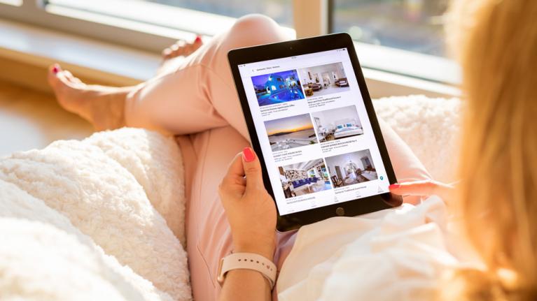 Frau schaut auf Website Buchungsportal mit Tablet