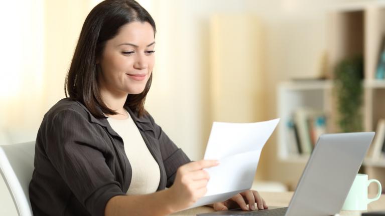 Frau mit Brief in Hand vor Laptop zu nowenergy