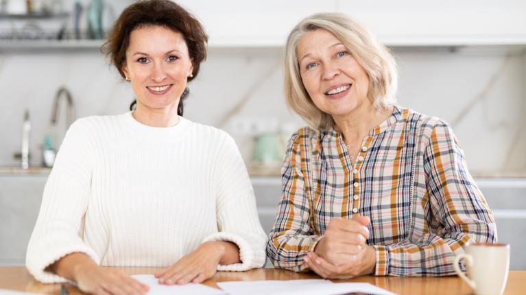 Seniorin und erwachsene Frau am Tisch, Pflegegradrechner