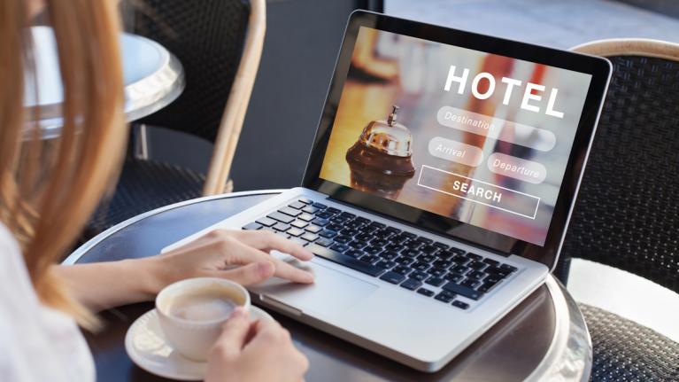 Frau vor Laptop will Urlaub buchen