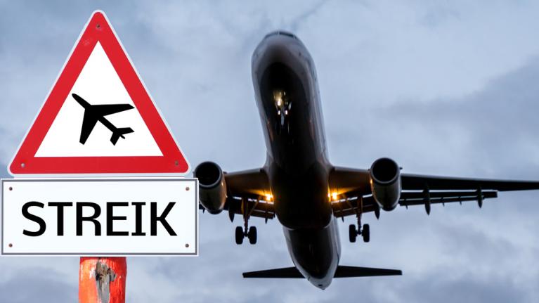 Abhebendes Flugzeug, davor Schild mit Streik