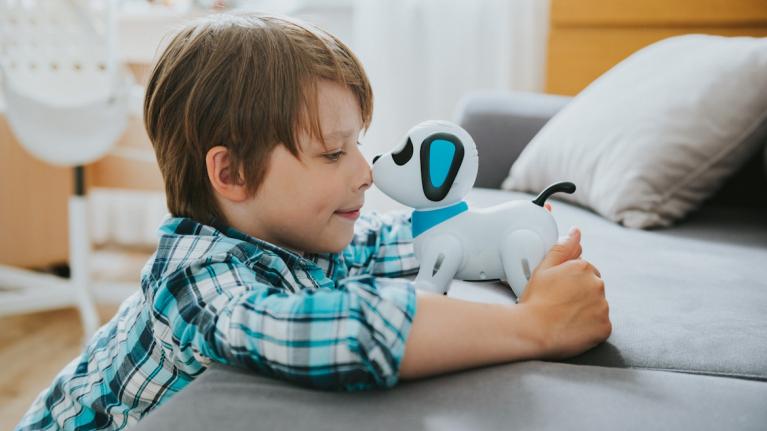 Smartes Spielzeug: Kind mit Roboterhund