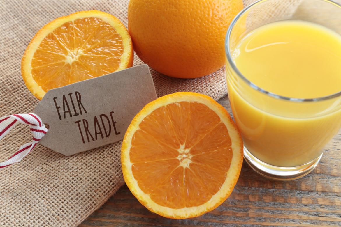 Glas mit Orangensaft und Etikett mit Fairtrade