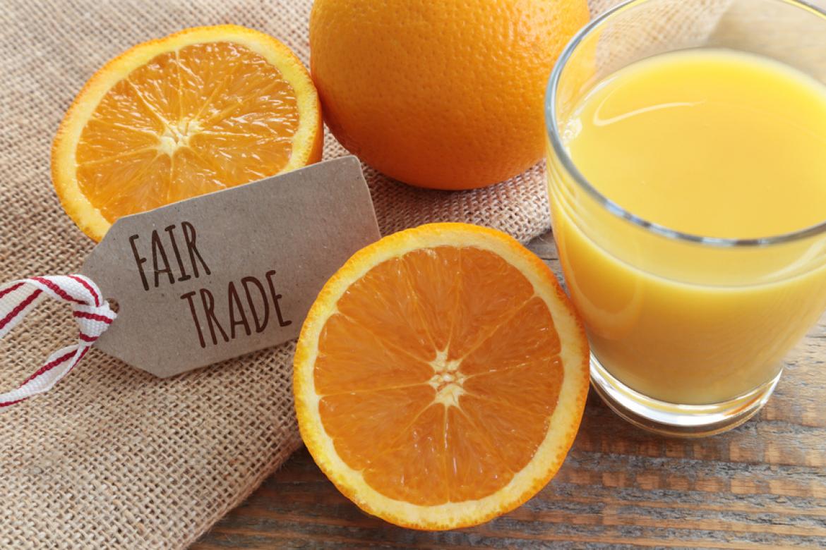 Glas mit Orangensaft und Etikett mit Fairtrade