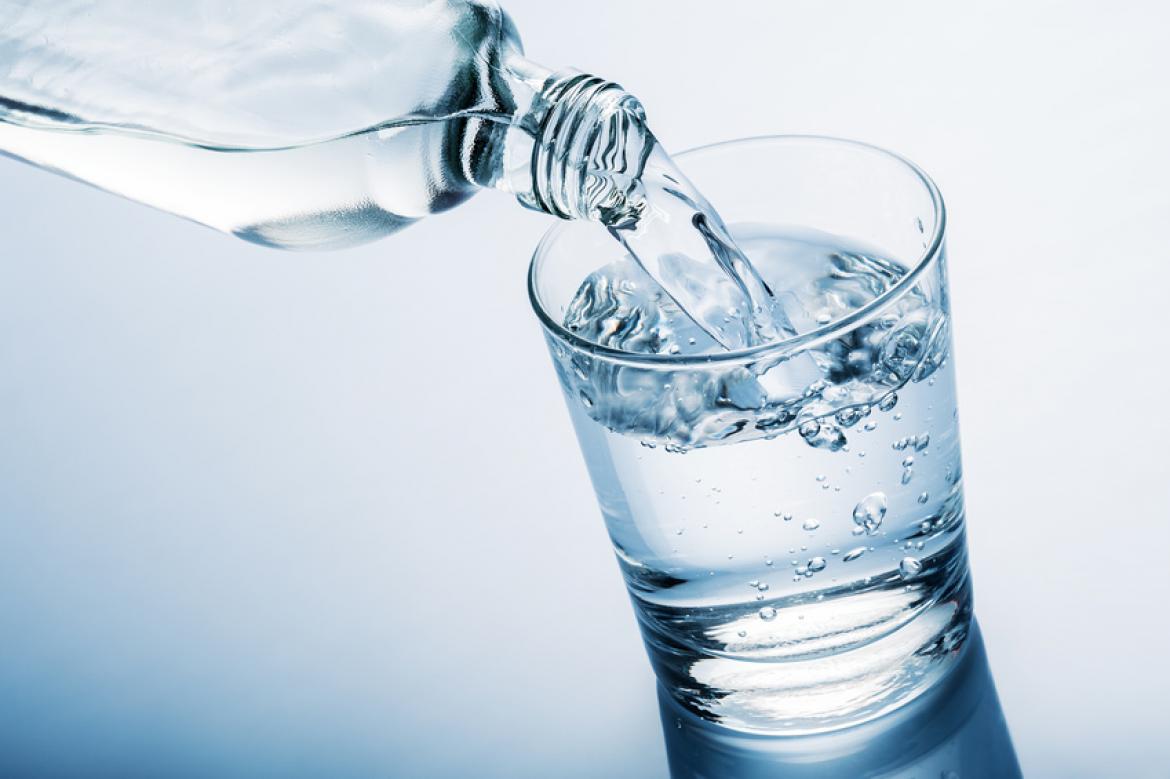 Wasser aus Flasche in Glas gegossen