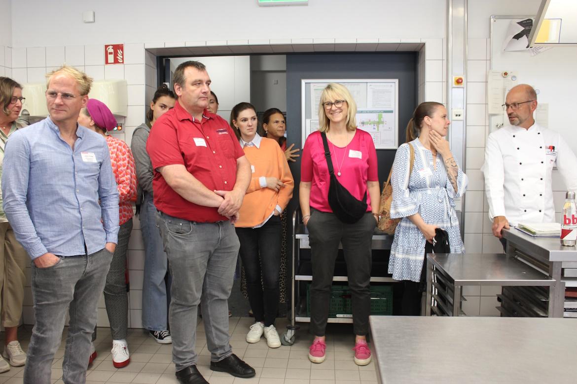 Mehrere Menschen im Austausch in Schulküche