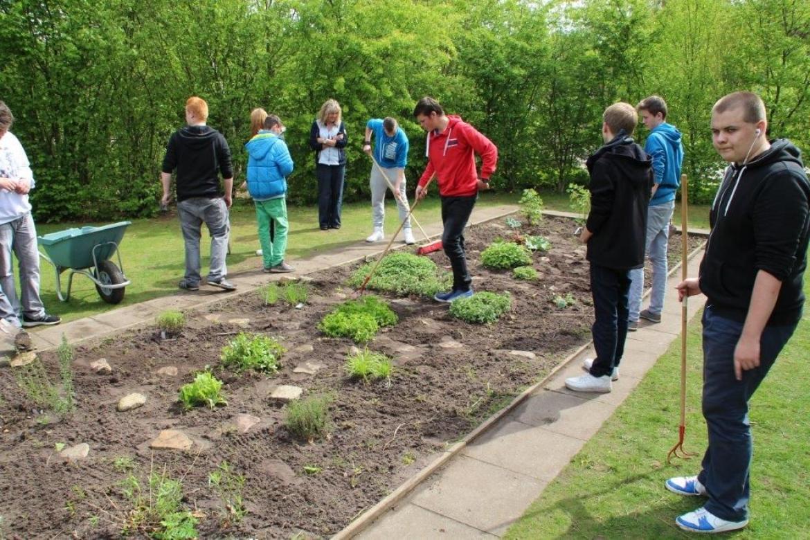 Schüler in einem Schulkräutergarten