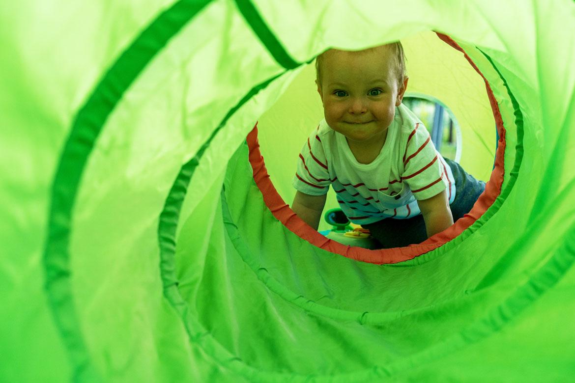 Kleinkind kriecht durch grünen Tunnel zu Artikel: Aktionsmaterial Tauch in deinen Bauch