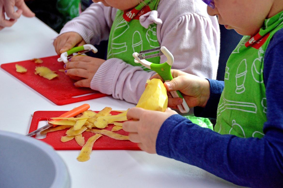 Kinder schälen Kartoffeln