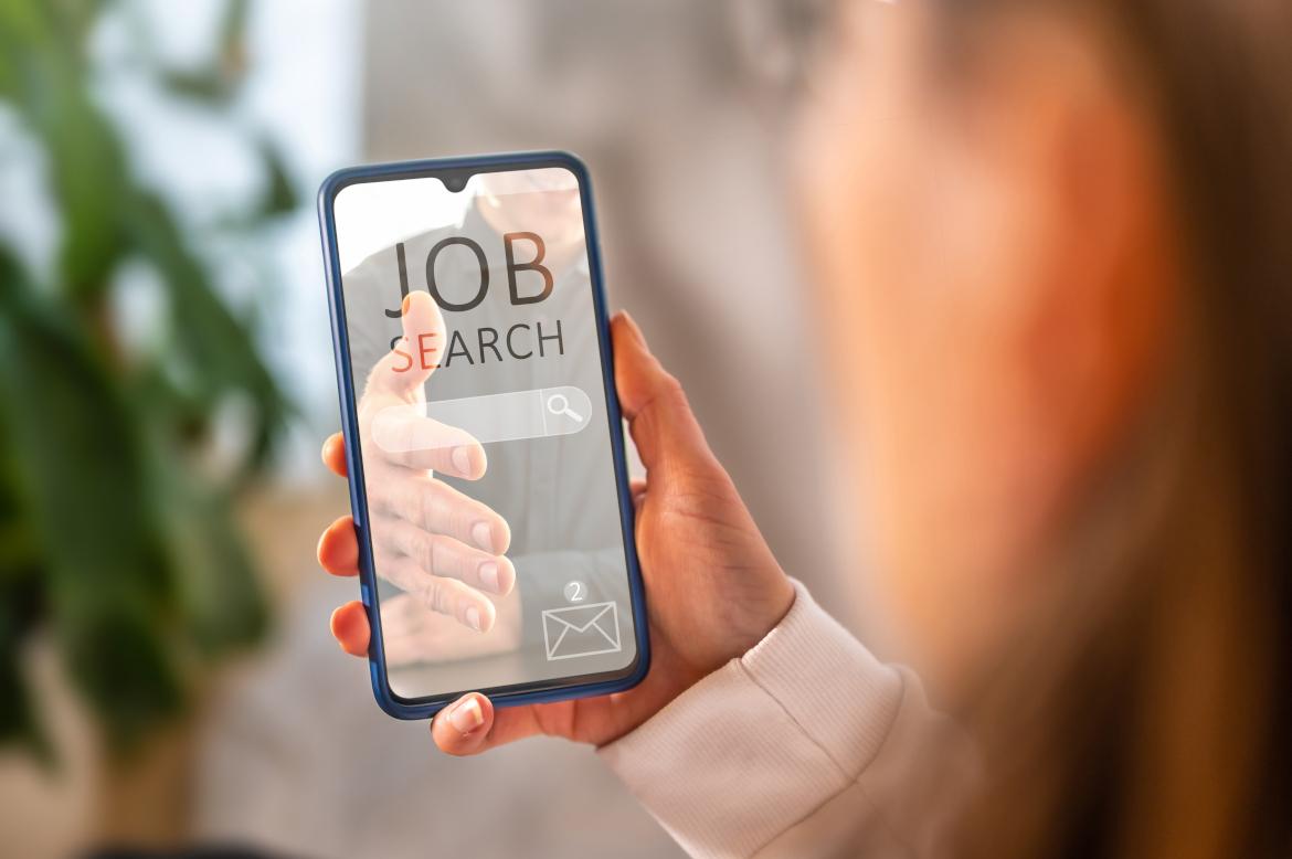 Person hält Smartphone mit Jobangebot in Hand
