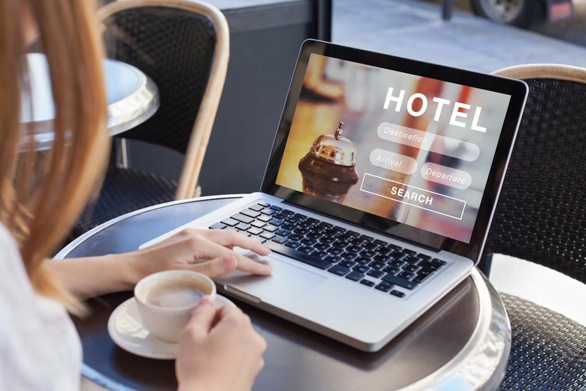 Frau vor Laptop will Urlaub buchen