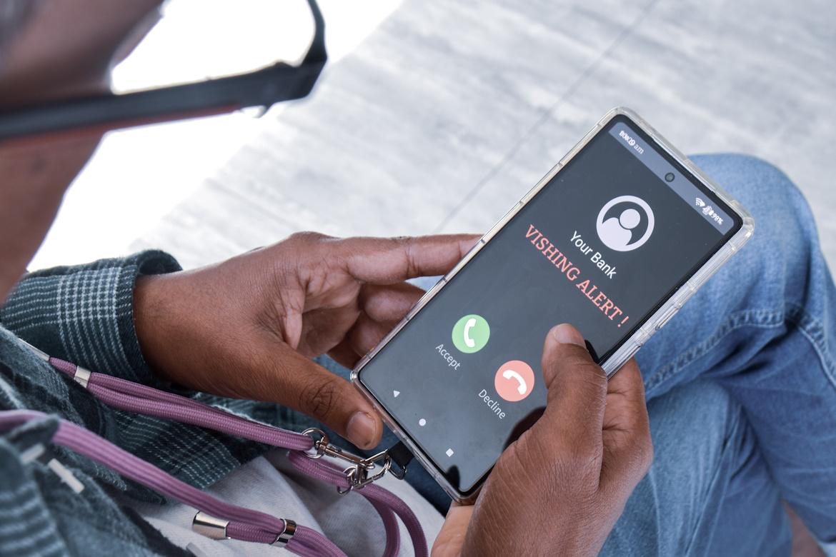 Mann erhält betrügerischen Anruf auf Smartphone. Vishing Alarm
