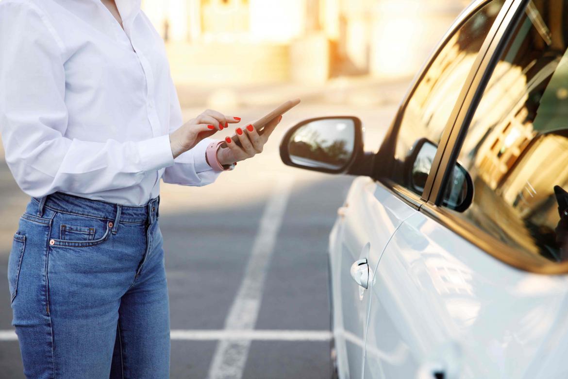 Frau macht mit Handy Carsharingauto auf