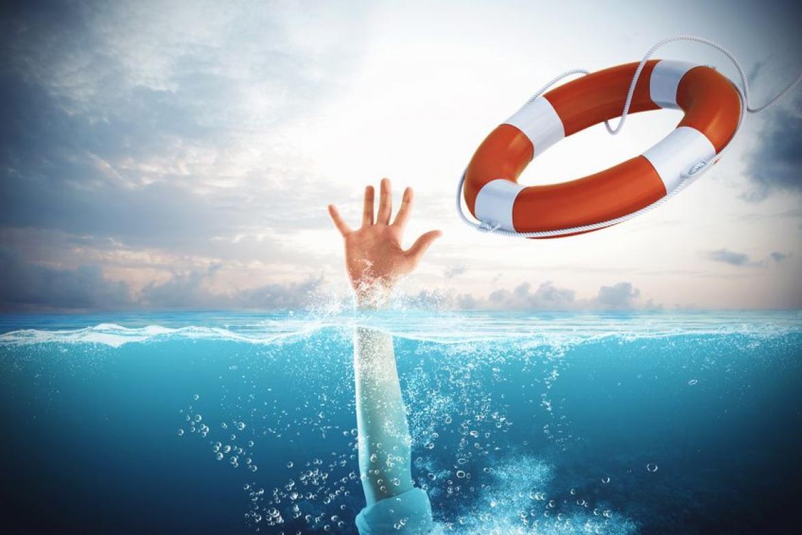 Hand greift nach Rettungsring aus dem Wasser