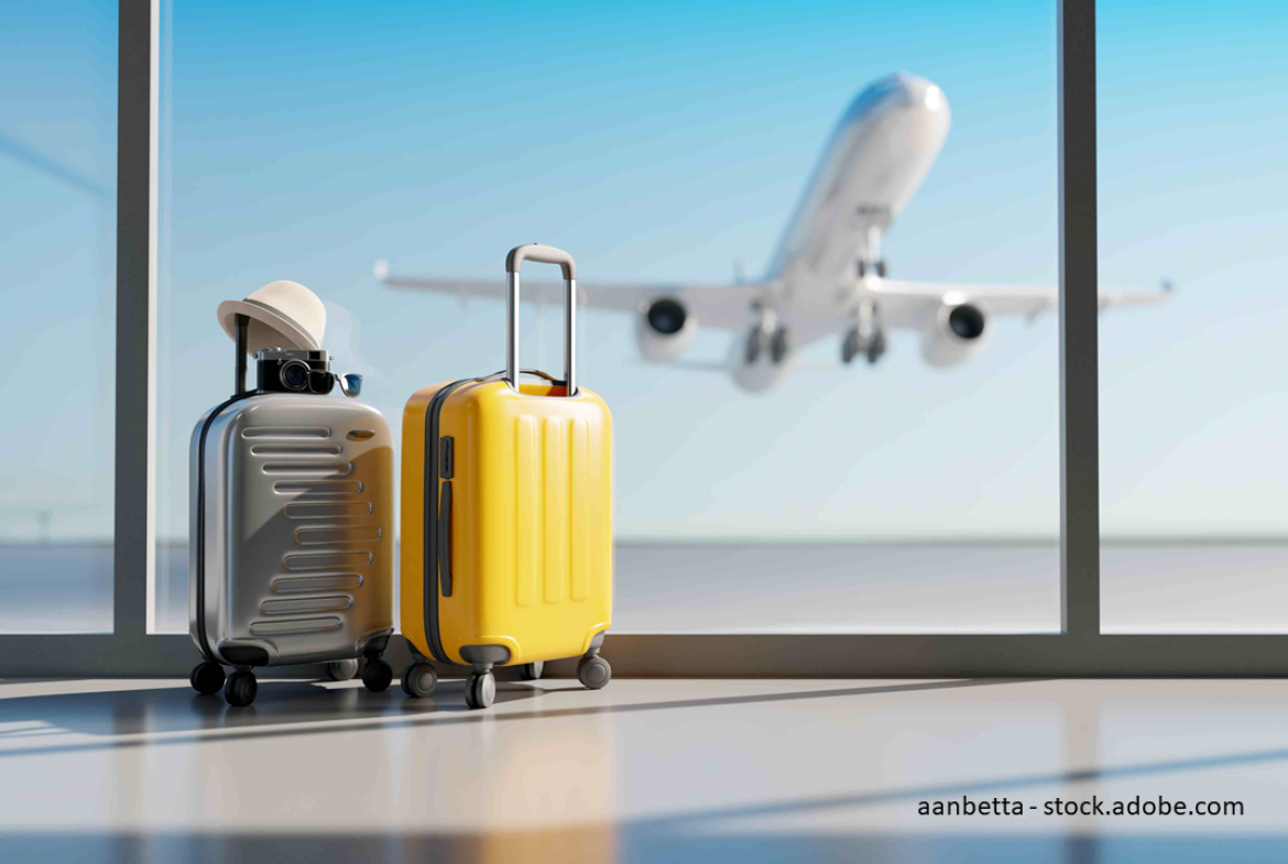 Koffer stehen alleine am Flughafen. Flieger hebt im Hintergrund  ab.