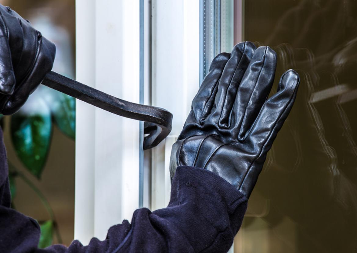Nahaufnahme beim Einbrechen, Hand und Hebel an Fenster