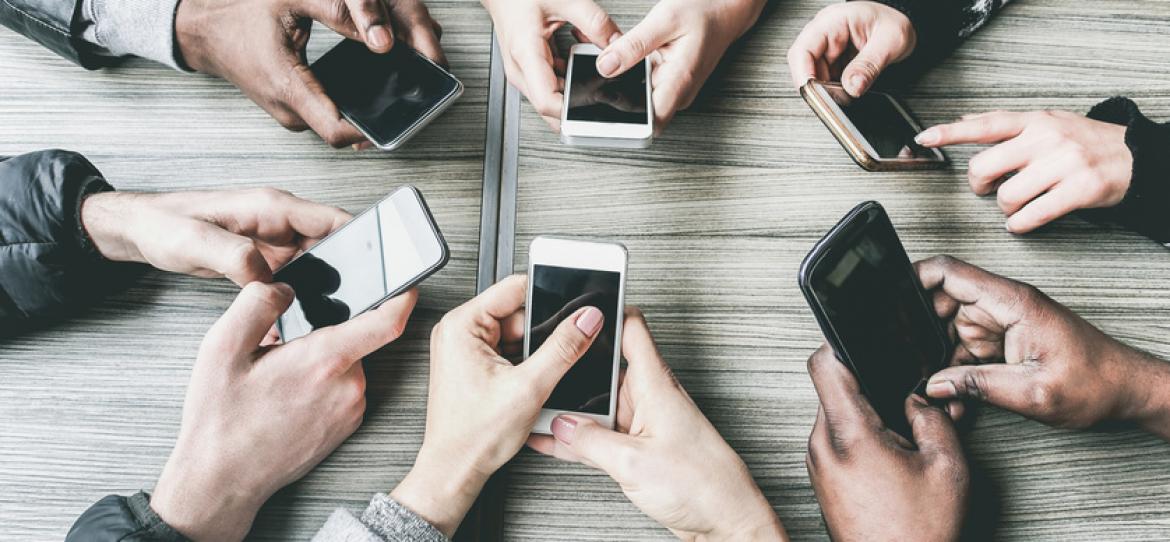 Viele Hände im Kreis mit Smartphones