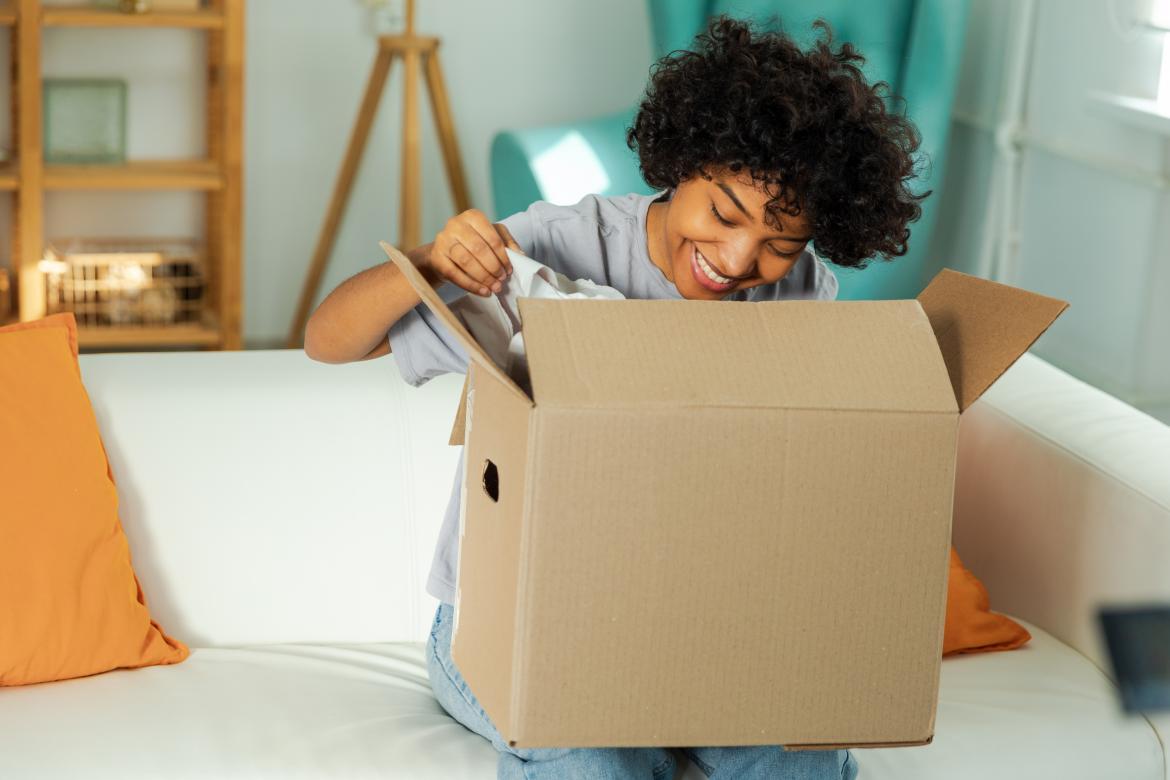 Mystery-Box Frau öffnet gespannt ein Paket