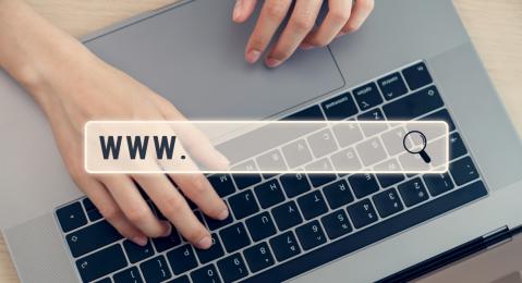 Draufsicht Laptop mit Händen, Eingabe URL