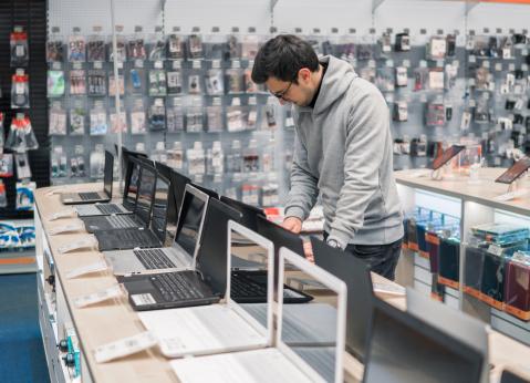 Mann will Laptop kaufen im Laden