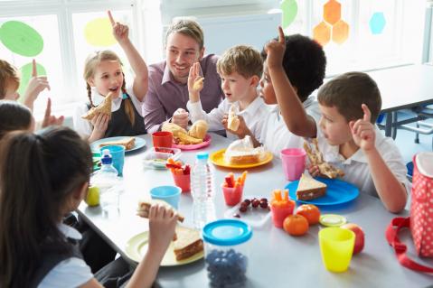 Grundschüler am Tisch beim Essen