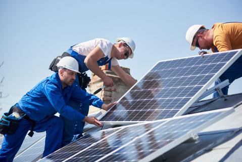 Männer installieren Solaranlage auf Dach