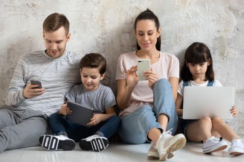 Familie auf Fußboden mit technischen Geräten