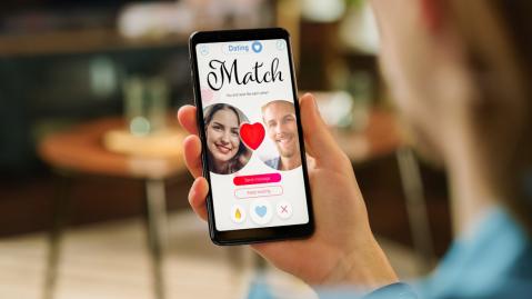 Frau nutzt Dating App auf Smartphone