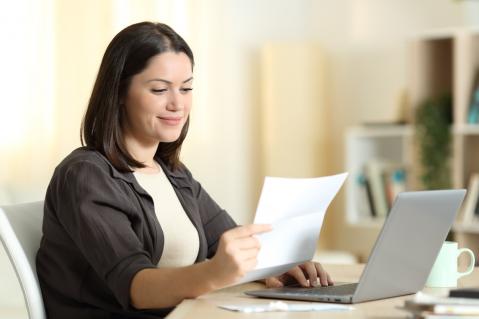 Frau mit Brief in Hand vor Laptop zu nowenergy