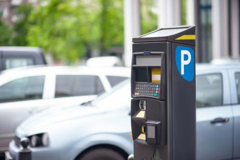 Parkautomat mit Autos im Hintergrund