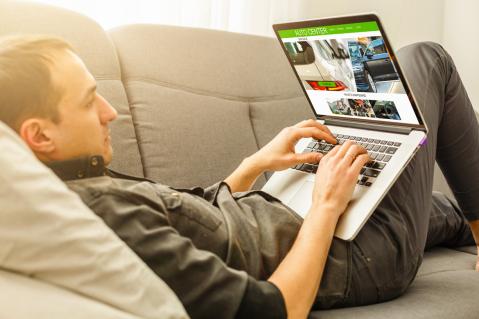 Mann auf Sofa mit Laptop zu Artikel: Phishingversuch beim Autokauf im Internet 