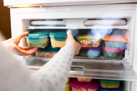 Frau stellt Boxen in Gefrierschrank